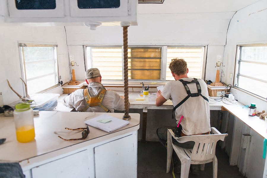 Crew leaders and project managers work at desks making production reports